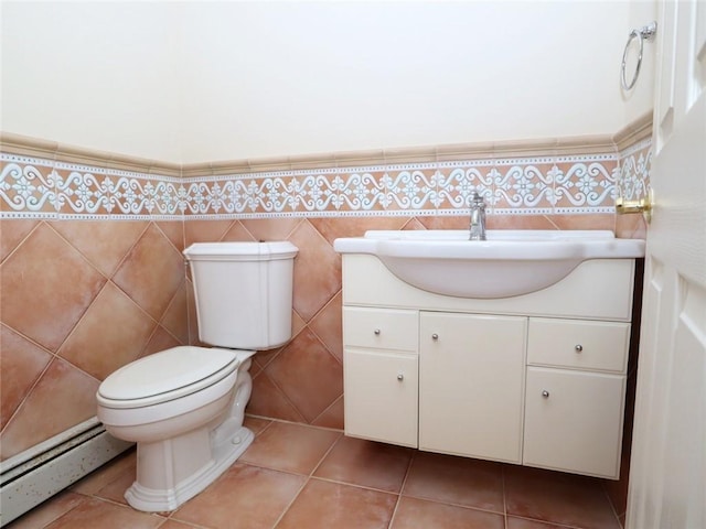 half bath featuring a baseboard radiator, vanity, toilet, and tile patterned flooring