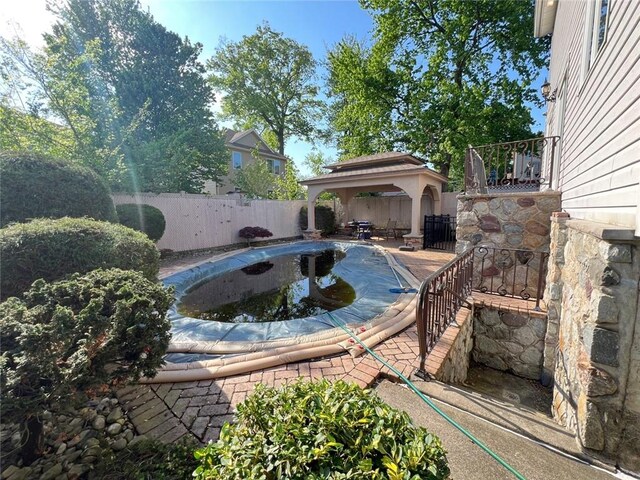 view of swimming pool featuring a gazebo and a fenced backyard