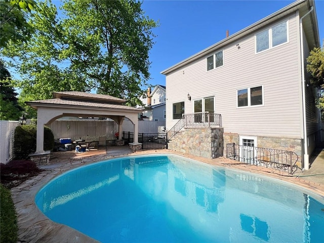 rear view of house with a gazebo, a fenced backyard, a patio, and stairs