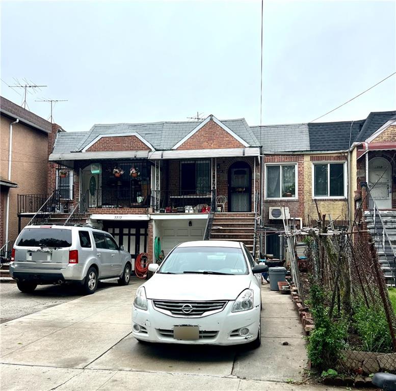 view of front of property with stairs, brick siding, and concrete driveway