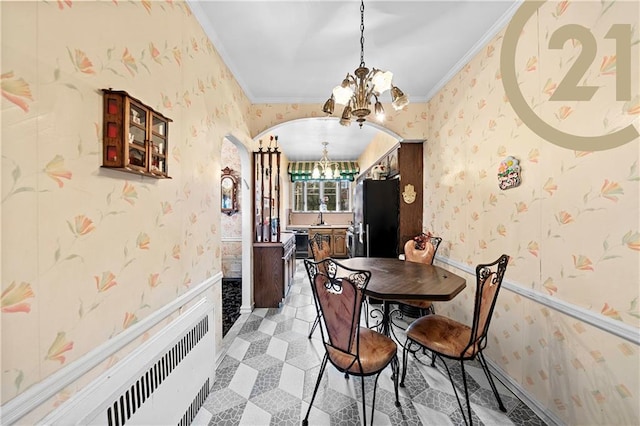 2138 E 26th St, Brooklyn, NY 11229 - dining room featuring a chandelier, ornamental molding, arched walkways, wallpapered walls, and radiator heating unit