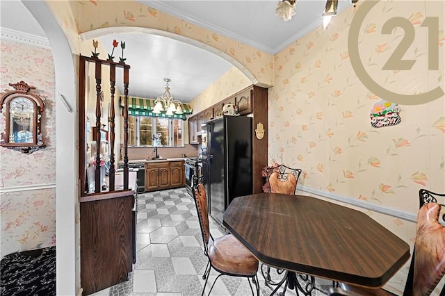 2138 E 26th St, Brooklyn, NY 11229 - kitchen featuring wallpapered walls, arched walkways, a chandelier, freestanding refrigerator, and a sink