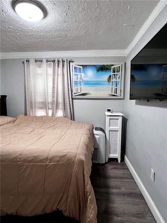 1202 E 46th St, Brooklyn, NY 11234 - bedroom featuring wood finished floors, baseboards, and a textured ceiling