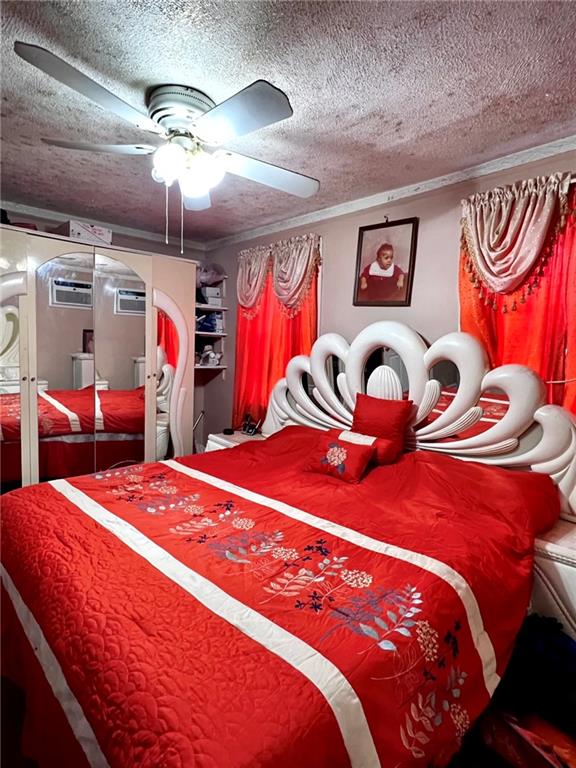 1202 E 46th St, Brooklyn, NY 11234 - bedroom with a textured ceiling, arched walkways, a ceiling fan, and a wall unit AC