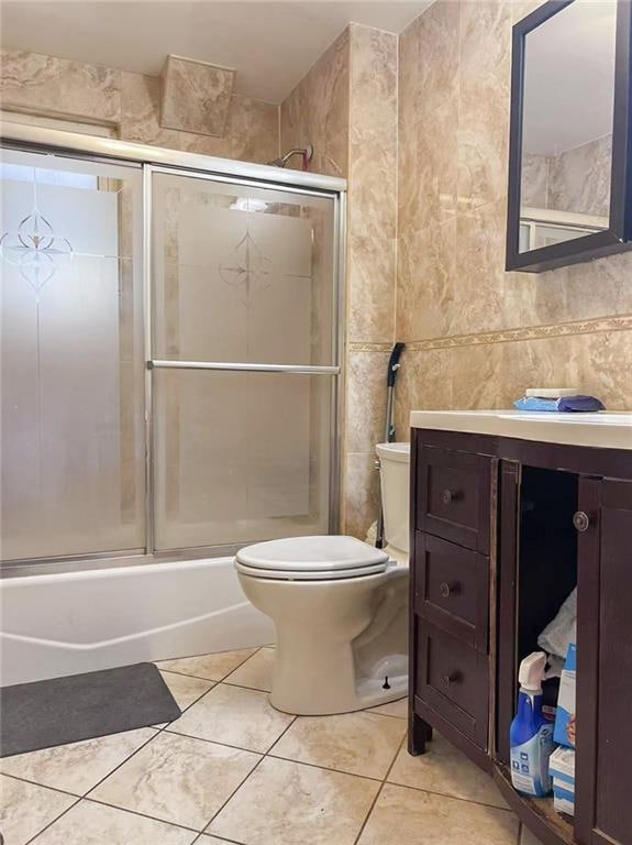 1202 E 46th St, Brooklyn, NY 11234 - full bathroom with tile walls, vanity, bath / shower combo with glass door, toilet, and tile patterned floors