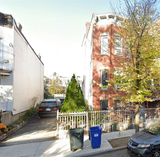 view of side of property featuring fence and brick siding