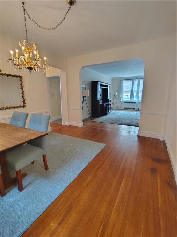 2195 E 22nd St Unit 5C, Brooklyn, NY 11229 - dining room with arched walkways, a chandelier, wood finished floors, and baseboards