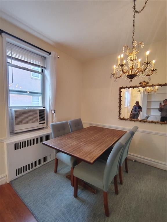 2195 E 22nd St Unit 5C, Brooklyn, NY 11229 - dining space with radiator heating unit, a chandelier, cooling unit, and wood finished floors