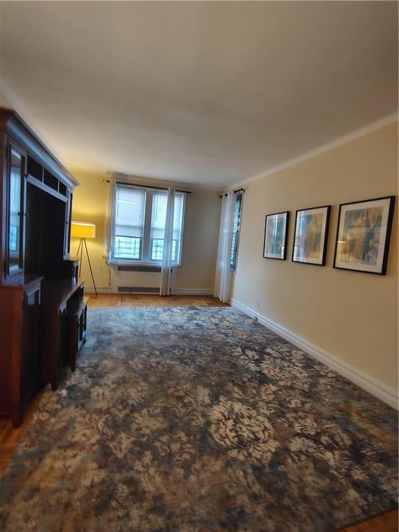 2195 E 22nd St Unit 5C, Brooklyn, NY 11229 - unfurnished living room featuring radiator heating unit, baseboards, and wood finished floors