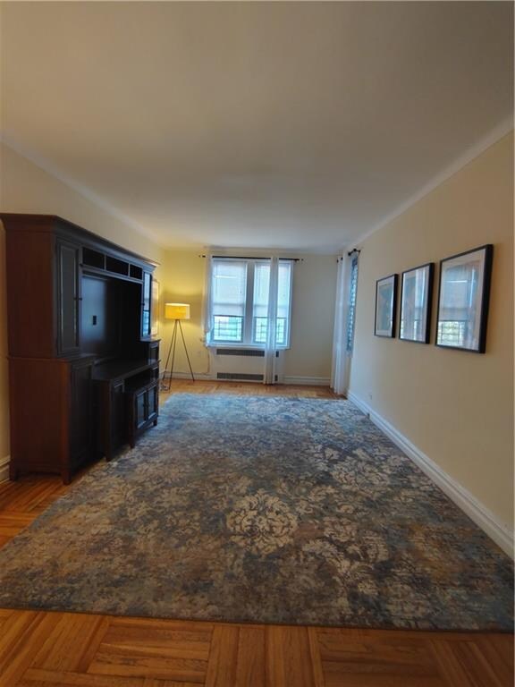 2195 E 22nd St Unit 5C, Brooklyn, NY 11229 - unfurnished living room featuring baseboards and radiator heating unit