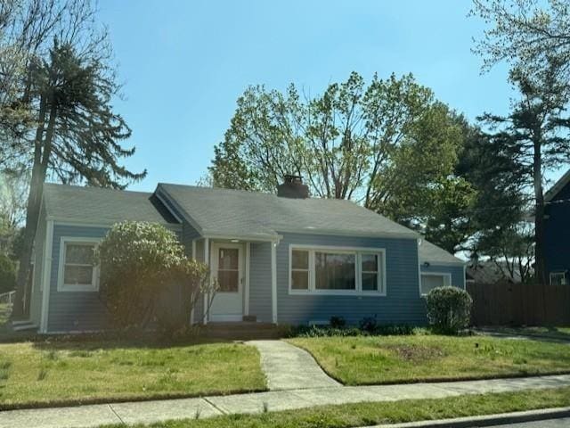 1669 Holly St, Baldwin, NY 11510 - view of front facade featuring a front yard and a chimney