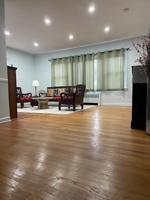 1669 Holly St, Baldwin, NY 11510 - living room with radiator heating unit, wood-type flooring, recessed lighting, and a fireplace