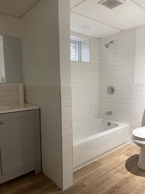 1669 Holly St, Baldwin, NY 11510 - full bath with tile walls, wood finished floors, shower / tub combination, vanity, and wainscoting