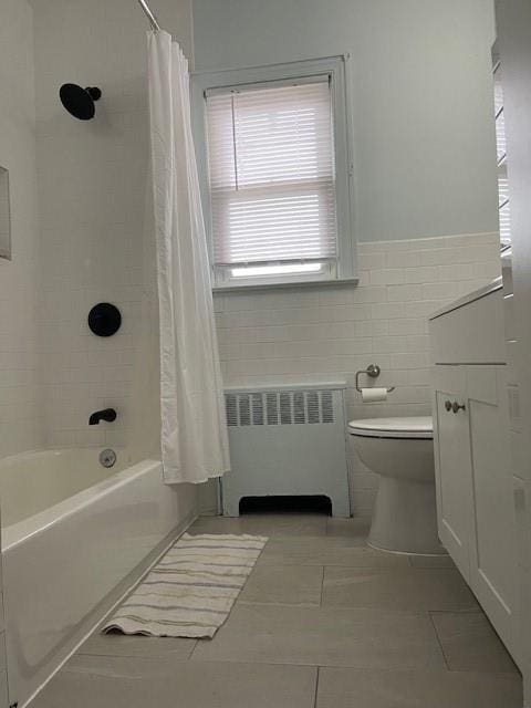 1669 Holly St, Baldwin, NY 11510 - full bath featuring radiator heating unit, shower / bath combination with curtain, tile patterned floors, tile walls, and a wainscoted wall