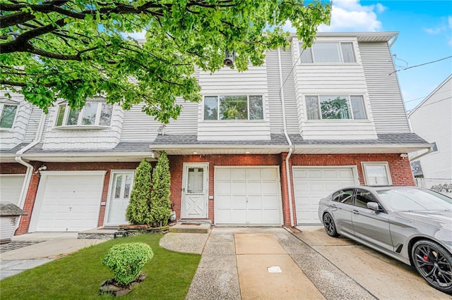 27 Frederick St, Staten Island, NY 10314 - townhome / multi-family property featuring brick siding, an attached garage, and driveway