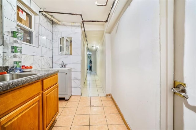 hall with light tile patterned floors and a sink
