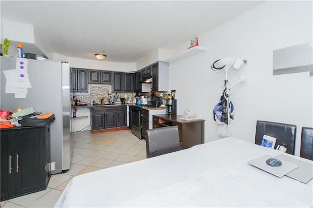 kitchen featuring appliances with stainless steel finishes, light tile patterned floors, tasteful backsplash, and under cabinet range hood