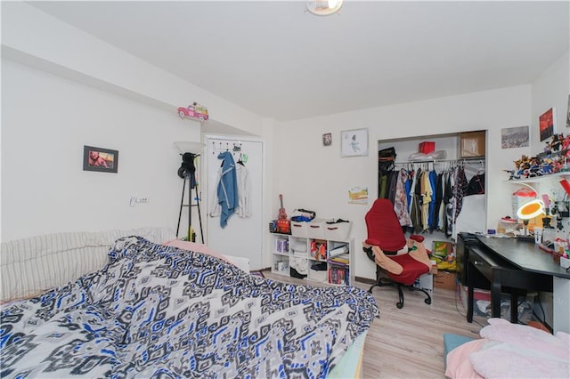 bedroom with wood finished floors and a closet
