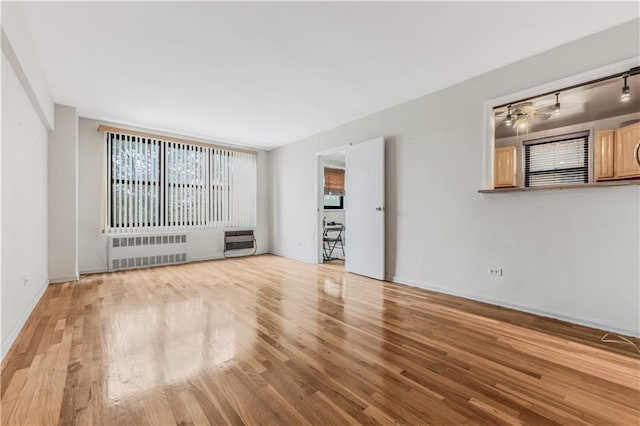 1165 54th St Unit 5U, Brooklyn, NY 11234 - unfurnished room featuring radiator, heating unit, wood finished floors, baseboards, and a ceiling fan