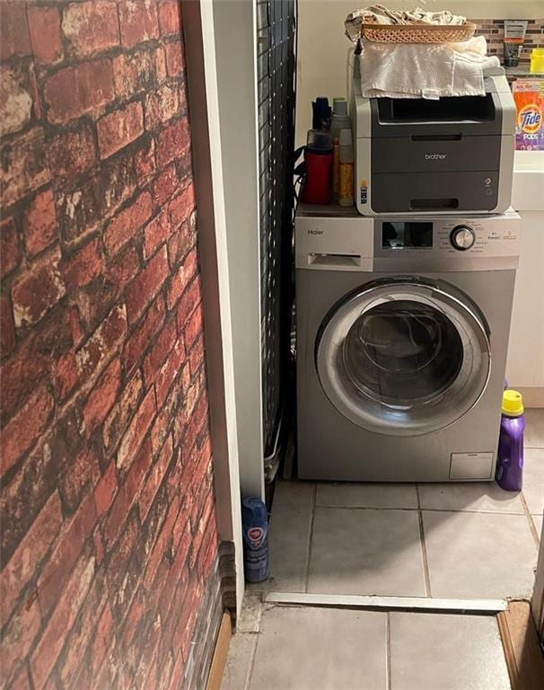 1120 Banner Ave, Brooklyn, NY 11235 - washroom with washer / dryer, brick wall, and tile patterned floors