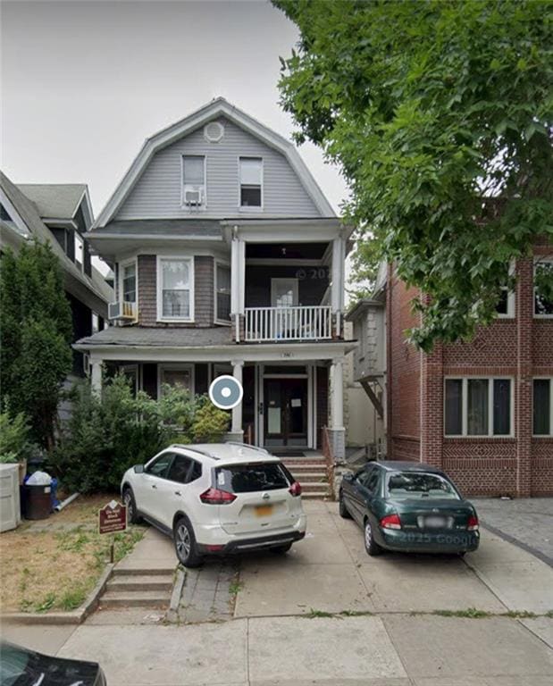 dutch colonial with a gambrel roof and a balcony