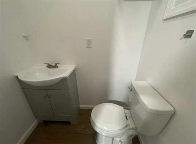 bathroom featuring vanity, toilet, and baseboards