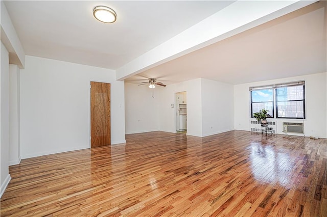 3101 Ocean Pkwy Unit 3H, Brooklyn, NY 11235 - unfurnished living room featuring light wood-type flooring, a ceiling fan, a wall unit AC, and baseboards