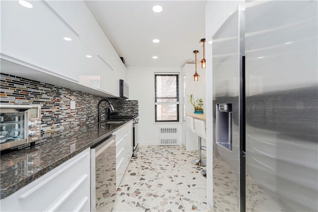 2546 E 13th St Unit A11, Brooklyn, NY 11235 - kitchen featuring stainless steel appliances, backsplash, recessed lighting, radiator, and white cabinets