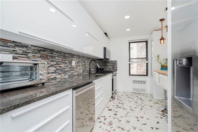 2546 E 13th St Unit A11, Brooklyn, NY 11235 - kitchen featuring appliances with stainless steel finishes, tasteful backsplash, a sink, recessed lighting, and dark stone countertops