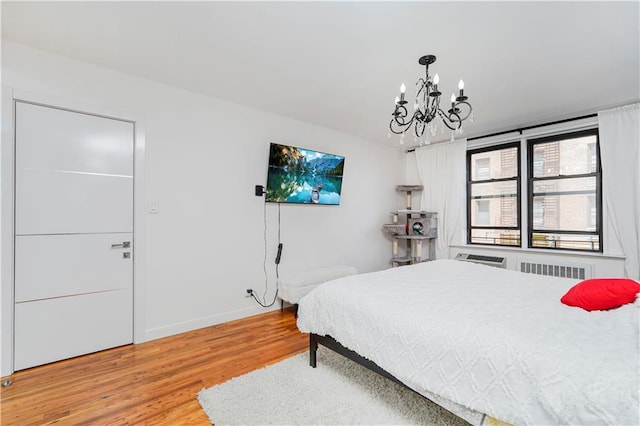 2546 E 13th St Unit A11, Brooklyn, NY 11235 - bedroom featuring a chandelier, light wood-type flooring, baseboards, and radiator heating unit