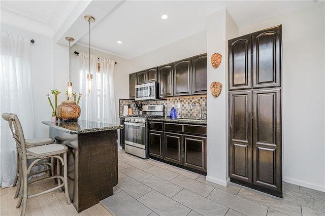138 Wakeman Pl, Brooklyn, NY 11220 - kitchen with stainless steel appliances, a kitchen breakfast bar, dark stone countertops, backsplash, and pendant lighting