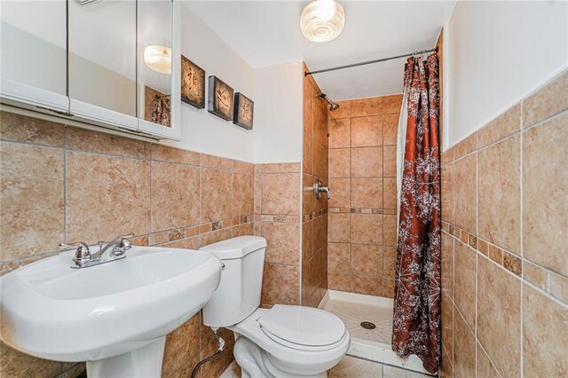 138 Wakeman Pl, Brooklyn, NY 11220 - full bathroom with tile walls, a shower stall, and a wainscoted wall