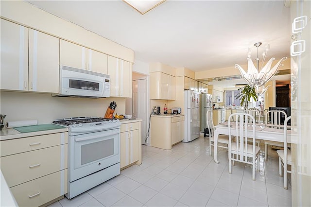 167 Bay 32nd St, Brooklyn, NY 11214 - kitchen with white appliances, a chandelier, light tile patterned floors, light countertops, and pendant lighting