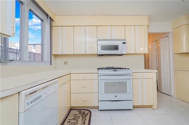 167 Bay 32nd St, Brooklyn, NY 11214 - kitchen with white appliances, light countertops, light tile patterned flooring, and white cabinetry