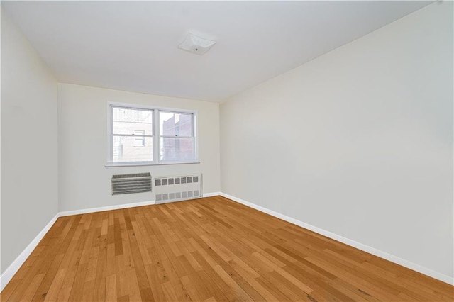 167 Bay 32nd St, Brooklyn, NY 11214 - empty room with radiator heating unit, light wood finished floors, and a wall unit AC