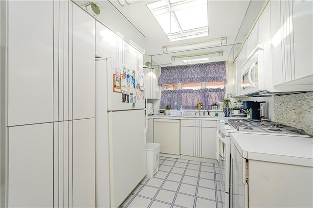 167 Bay 32nd St, Brooklyn, NY 11214 - kitchen featuring white appliances, light countertops, tasteful backsplash, white cabinetry, and a skylight
