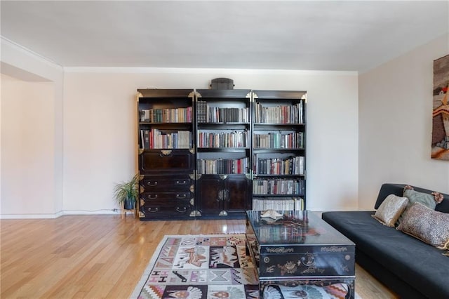 sitting room with wood finished floors and ornamental molding