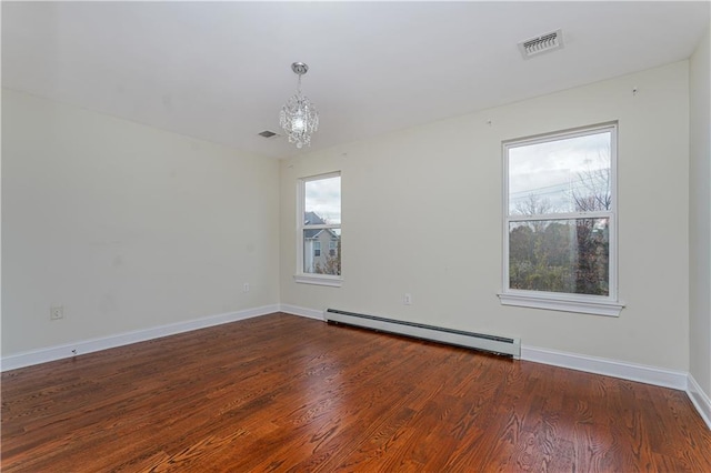 empty room with baseboard heating, a chandelier, wood finished floors, and baseboards