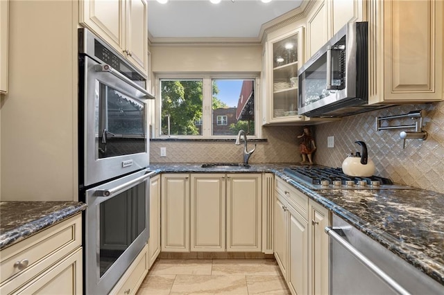 2472 Stuart St, Brooklyn, NY 11229 - kitchen with appliances with stainless steel finishes, cream cabinetry, backsplash, and ornamental molding