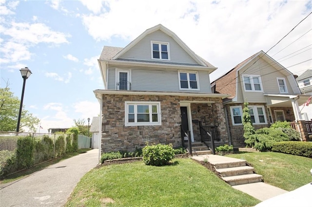 american foursquare style home featuring stone siding