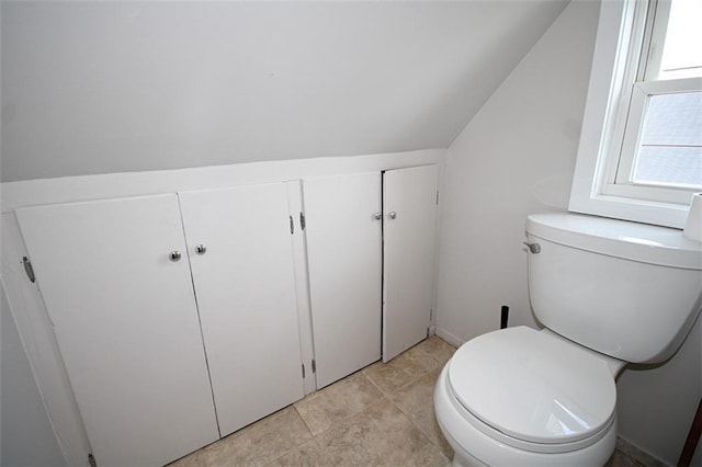 bathroom featuring lofted ceiling, toilet, and tile patterned flooring