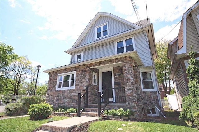 american foursquare style home featuring stone siding