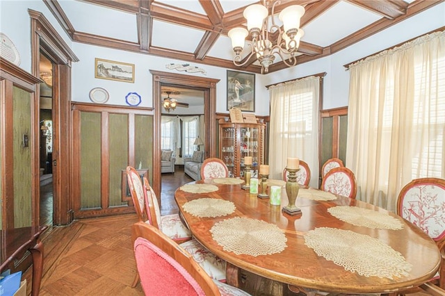 dining room featuring coffered ceiling, plenty of natural light, a chandelier, a decorative wall, and a wainscoted wall