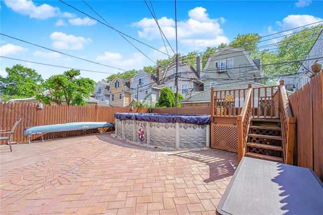 view of patio featuring a fenced backyard, a wooden deck, and a residential view