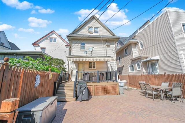back of property with a patio, a fenced backyard, a wooden deck, and outdoor dining area