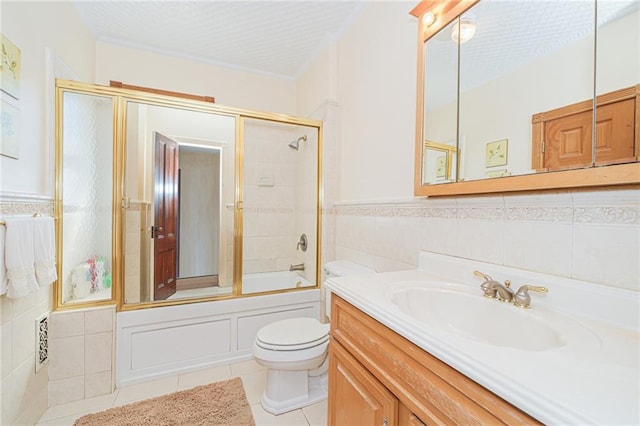 full bath with tile patterned flooring, tile walls, toilet, vanity, and enclosed tub / shower combo