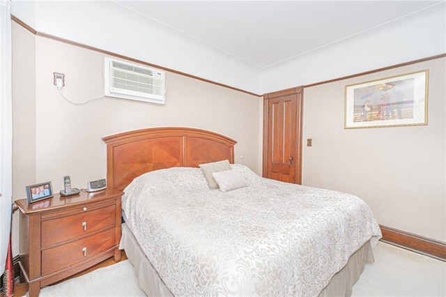 bedroom with a wall mounted AC and light carpet
