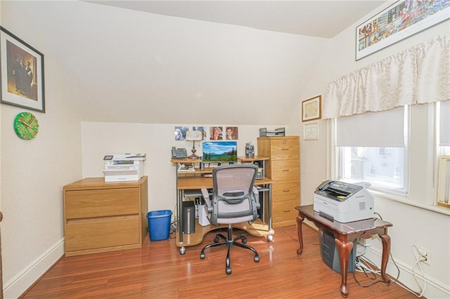 office area with wood finished floors, baseboards, and vaulted ceiling