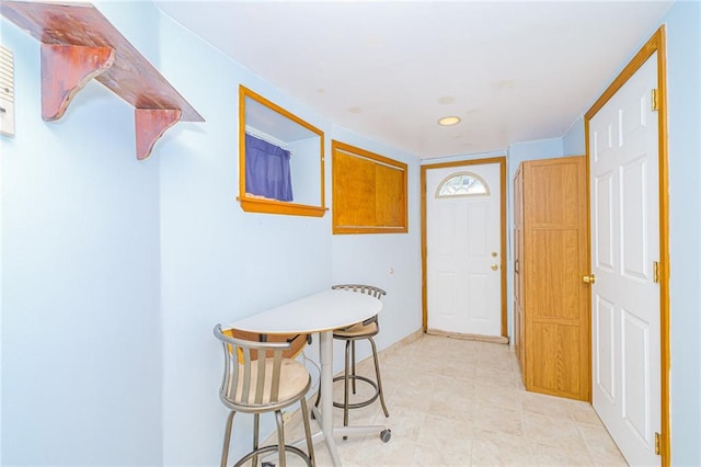 foyer entrance with baseboards, light tile patterned floors, and recessed lighting