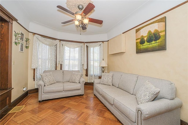 living area featuring a ceiling fan and baseboards